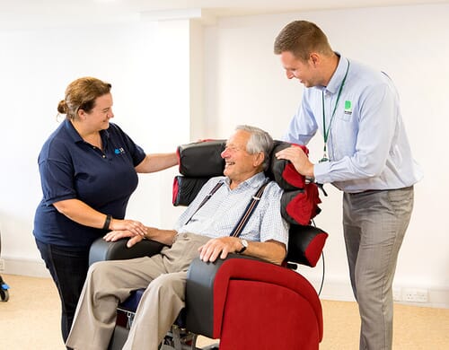 Two healthcare professionals looking after man in chair. 