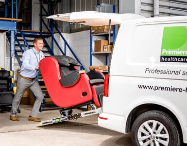Man loading red chair into van.