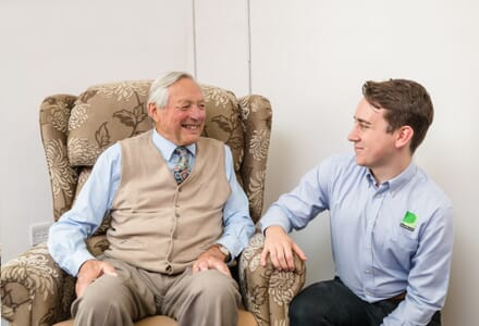 Premiere healthcare seating expert talking to elderly man about specialist chair